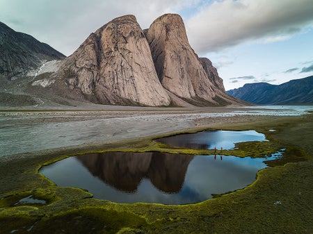 Large rock formation with small lake in foreground