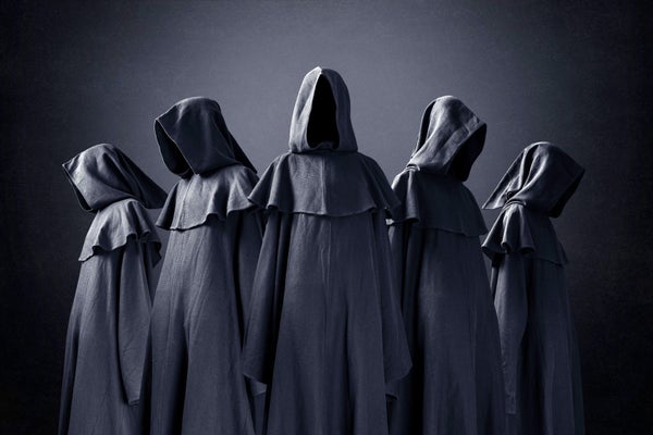 Group of five scary figures with no faces in hooded cloaks in the dark