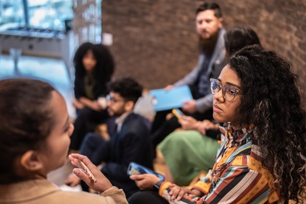 Young woman listening a colleague in a seminar