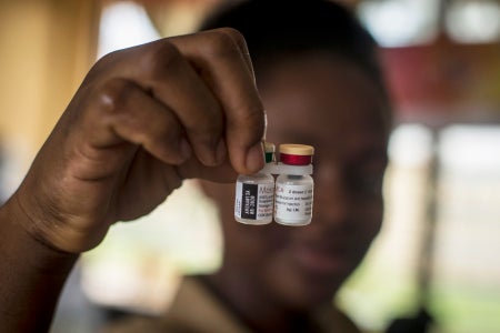 Close-up of nurse holding vaccine bottles.