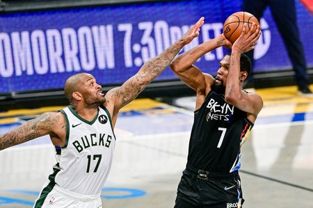 Basketball player Kevin Durant attempts a shot against P.J. Tucker