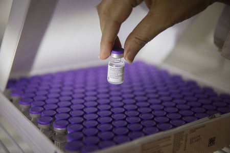 A nurse handles a vial of the the Pfizer-BioNTech Covid-19 vaccine