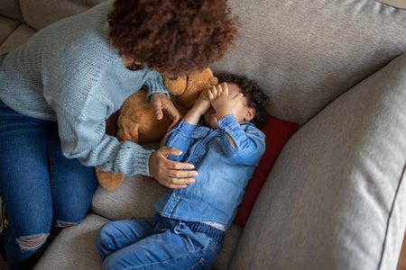 High angle view of mother trying to comfort her grumpy toddler son