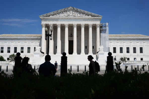 Supreme court with shadowed people walking across